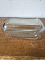 Closed view of vintage Art Deco glass butter dish with lid on wooden surface