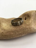 Angle view of vintage sterling silver ring showing ridged or scalloped design and surface wear.