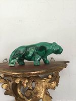 Front angle view of carved malachite cougar showing polish and shape.
