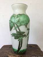 Front view of the tall cameo glass vase showing green leaves and birds on white glass background