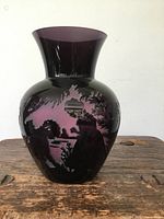 Front view of the purple glass vase showing a cutout scenic design with trees and a figure.