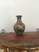 Front view of tiny cloisonne vase showing detailed flower and leaf patterns.