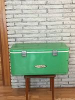 Full front view of green vintage chest cooler with white trim and metal latches, branded Holiday Thermos.