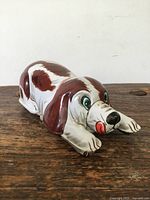 Side view of the tin dog toy showing painted details and condition of the item.