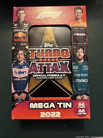Front view of the sealed Topps Turbo Attax Mega Tin for 2022 Formula 1 featuring driver images and logo with star design.