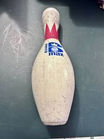 Top-down view of white Brunswick Max bowling pin with red crown decal, visible scuff marks and branding