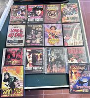 Photo showing 14 martial arts movie DVDs arranged on a table, featuring titles and artwork typical of vintage martial arts films.