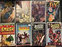 Photo showing 8 comic books including Ghost Manor, The Reel, Dead Again, The Fly, Smash Comics, The Trouble with Girls, and two Dirty Pair comics with different covers.