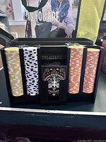 Poker chips in five colors and deck of cards inside metal ammo box