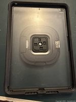 Tablet case with clear back showing the locking mount mechanism inside, designed for protection and secure attachment.