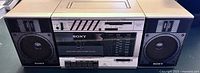 Front view of vintage Sony boombox with cassette deck and radio tuner showing brand and model details.