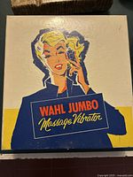 Closed original box showing vintage illustration of a woman using the device and bold 'Wahl Jumbo Massage Vibrator' text.