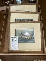 Photo of 3 framed Asian artworks stacked, showcasing matting and signed paintings.
