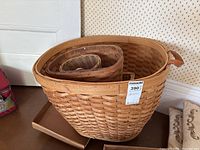 Large wood woven basket with handle, with smaller baskets nested inside and flat wooden tray beneath