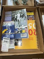 Boston Marathon memorabilia including official programs, printed photos, and blue fabric marathon arch banner folded in plastic wrap