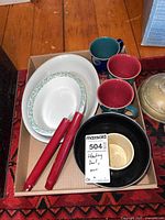 Overview of lot showing J&G Meakin bowl, four colorful mugs, black and cream bowl, and red taper candles