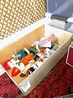 Five nutcracker figures laid inside a cardboard box, showing a view with varying styles including Santa Claus and soldiers.