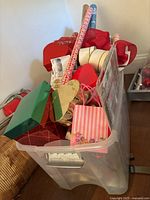 Container full of assorted Christmas gift bags, boxes, and wrapping papers