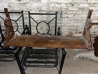 Photo of the underside of the wooden display shelf showing surface scratches and worn finish.