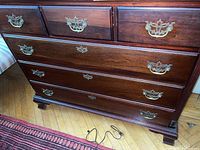 Full front view of the mahogany dresser showing all drawers and metal pull handles.