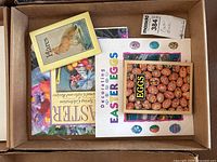 Top view of box containing five Easter themed craft and decorating books focusing on decorated eggs and hares.