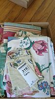 Box of assorted fabric remnants including 'Mt Vernon' pattern fabric with large floral motifs and striped fabric.