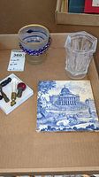 Box contents showing goblet, octagonal vase, finials with bulbs, and vintage printed tile