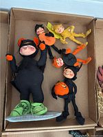 Four Halloween-themed Annalee costumed children dolls in a box.