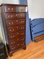 Full front view showing tall chest with brass handles