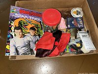 Photo of the boxed collection showing Star Trek book and record set, jar of marbles, red and black gloves, pin, small toy boxes, and baseball playing cards.
