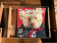 Photo of The Teddy Bear Calendar 1991 showing the teddy bear on the cover wearing a denim jacket and red scarf.