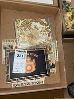 Open box containing assorted cigar and cigarette labels, some organized in plastic bags.