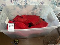 Clear plastic bin filled with red velvet fabric remnants.