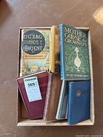 Box of 7 vintage books including 'Mother Goose for Grown-ups' and 'Zig Zag Journeys to the Orient' showing wear and damage.