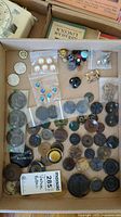 Overview of the full collection of vintage buttons showing a variety of sizes, colors, and materials laid out in a box.