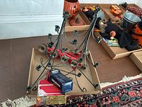 Original box of Swedish Christmas candles and three black metal candelabras arranged on floor.