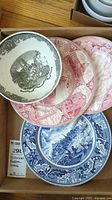 Photo of five vintage Massachusetts Boston commemorative transferware plates including black, red, and blue designs showing historic scenes.