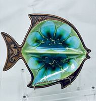 Front view of fish-shaped Treasure Craft pottery dish with blue and green glaze and brown textured detailing.