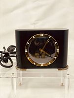 Front view of black rectangular vintage WestClox clock with visible gold-tone bezel and hands, showing clock face clearly.
