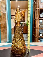 Full view of the amber glass genie bottle with a measuring tape showing approximately 14 inches in height.