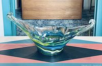 Front view of vintage multicolor Sooner art glass dish basket showing flared sides and colorful horizontal bands inside thick clear glass.