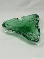 Top angle view of the triangular teal glass dish showing the curved flowing shape and color.