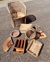 Photo showing all 8 items arranged on asphalt, including the wicker armchair, rectangular basket, round basket, fan-shaped tray, wooden organizer tray, and others.