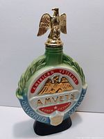 Front view of ceramic decanter with American Veterans eagle emblem and AMVETS text.