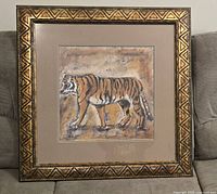 Full framed tiger print showing geometric carved wood frame with damage on the side.