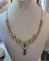 Front view of the vintage rhinestone necklace on a display bust, showing the arrangement of rhinestones and design details.