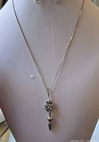 Full view of the sterling silver necklace displayed on a jewelry bust, showing the chain and pendant length and style.