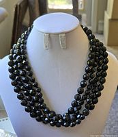 Front view of the three-strand black glass bead necklace on display bust.