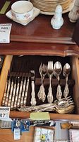 Wooden drawer with ornate Community flatware arranged by type