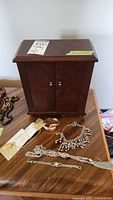 Wooden jewelry box with costume jewelry items displayed in front